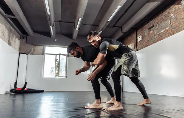 Sparring training of two athletic mma fighters in the gym. Martial arts, Wrestling