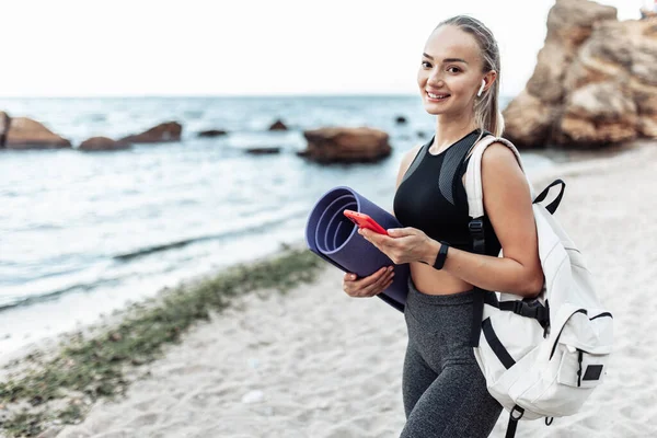 Fit Woman Yoga Mat Backpack Using Phone Wild Beach — Stockfoto