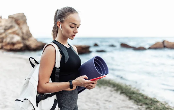 Fit Woman Yoga Mat Backpack Using Phone Wild Beach — Stockfoto