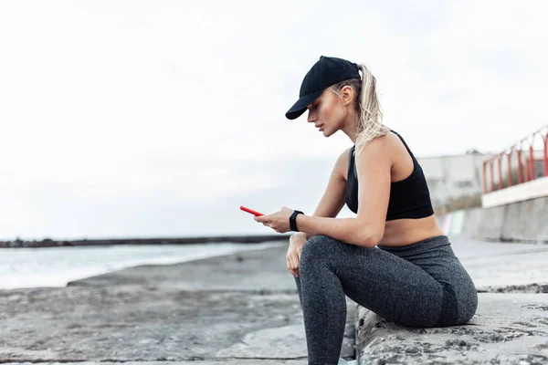 Fit Woman Sportswear Using Smartphone While Sitting Urban Beach — Stock Fotó