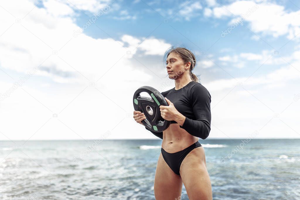 Strong athletic woman exercising with barbell