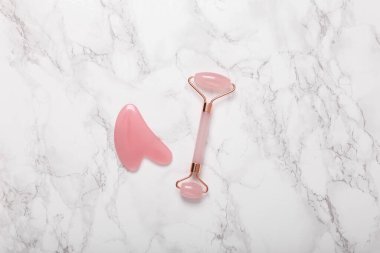 Mermer zemin üzerinde Guasha taşı olan yeşim masaj silindiri.