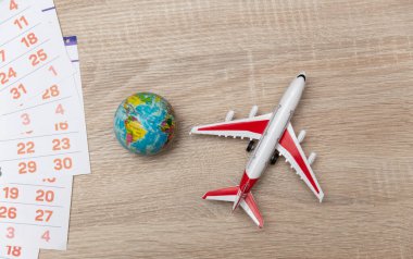 Masada uçak ve küre olan kağıt takvim. Seyahat konsepti. Üst görünüm