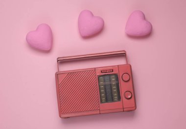 Pembe arka planda kalpleri olan eski radyo alıcısı. Romantik melodi. Üst görünüm