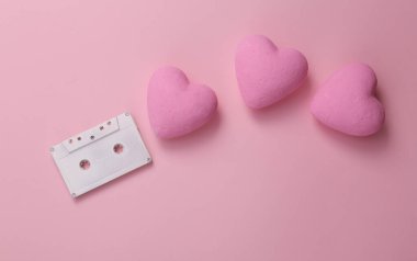 Pembe arka planda kalpleri olan bir kaset. Romantik melodi. Üst görünüm