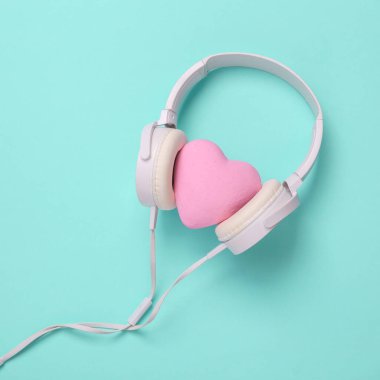 Headphones with heart on a blue background. Romantic melody. Top view