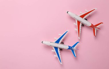 Two Toy model airplanes on pink background. Travel concept. Flat lay, top view
