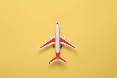 Sarı arka planda model uçak. Seyahat konsepti. Düz yatış, üst görünüm