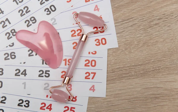 Calendar with facial massage roller on table