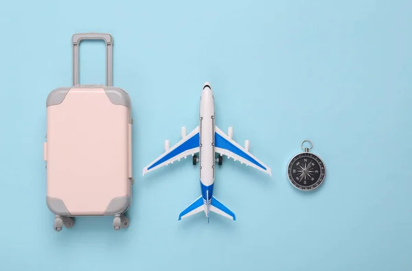 Passenger airplanes with luggage and compass on blue background. Travel concept. Flat lay, top view