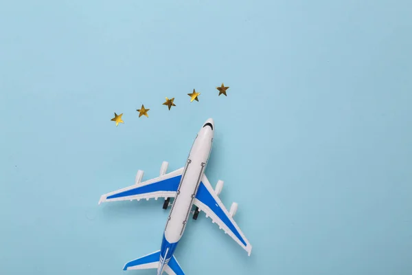 Excellent air service. Model of a passenger plane with 5 gold stars on a blue background. Travel concept. top view