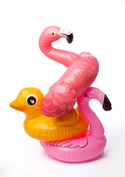 Şişirilebilir pembe flamingo ve ördek beyaz arka planda izole edilmiş.