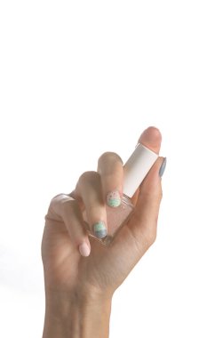 Female hand holding nail polish bottle isolated on white background