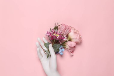 Beauty, love, romantic concept. Hand holding flowers on pink background. Top view. Flat lay
