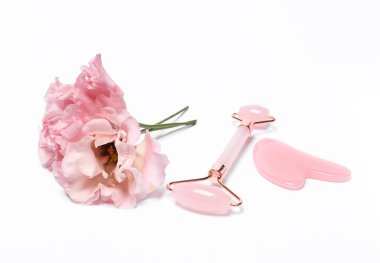 Massage facial roller and a stone with flower on white background. Beauty, facial skin care concept