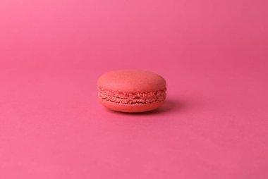 Pink macaroon on pink background. French sweet delicacy. Color trend