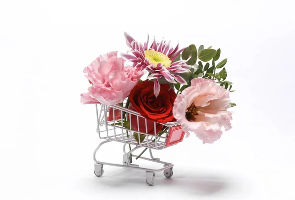 Shopping cart with many different flowers isolated on white background