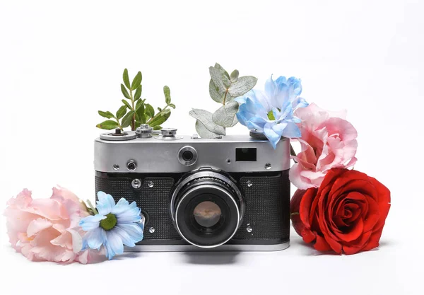 Retro camera with flowers isolated on white background