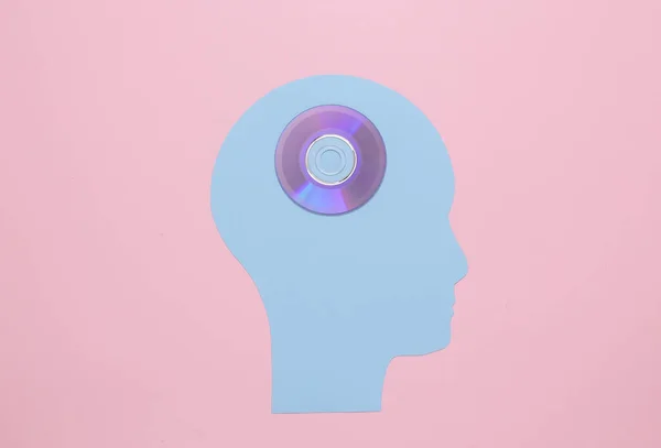 Paper cut head with sd disk on a pink background. Storage of memories