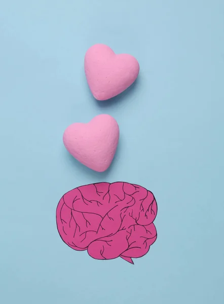 paper-cut brain and hearts on a blue background. Falling in love concept