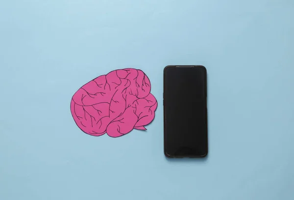 Paper-cut brain with smartphone on a pink background. AI technology