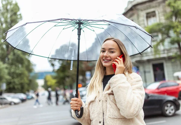Smiling Fashion Blonde Woman Transparent Umbrella Talking Phone City Lifestyle — Stockfoto