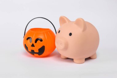 Piggy bank with halloween jack pumpkin bucket isolated on white background. Trick or Treat