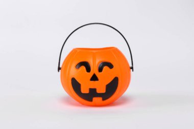 Orange plastic Trick Or Treat candy bucket. Jack O' Lantern Halloween pumpkin pail isolated on white background