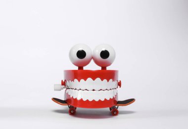 Clockwork joke jaw with skateboard isolated on white background