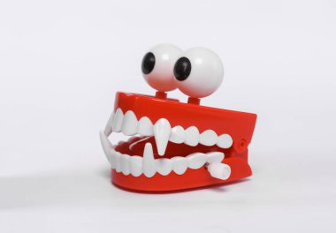 Clockwork jaw with vampire fangs isolated on white background