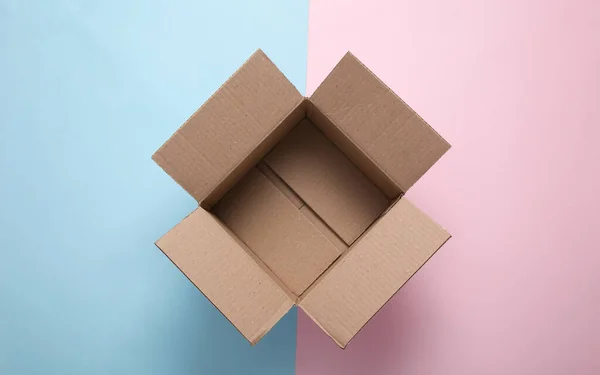 Open empty cardboard box on a blue-pink pastel background. Top view