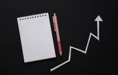 Analitik, istatistik, iş konsepti. Siyah arka planda not defteri olan büyüme oku. Üst görünüm