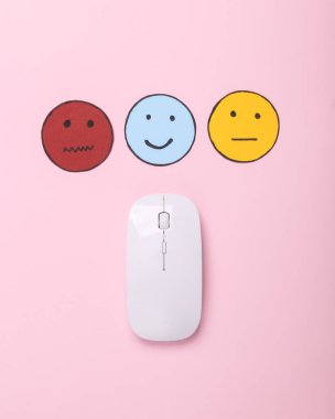 Müşteri memnuniyeti araştırması konsepti. PC fare seçimi mutlu yüz simgesi, pembe arka planda nötr ve üzgün yüz simgesi. Üst görünüm
