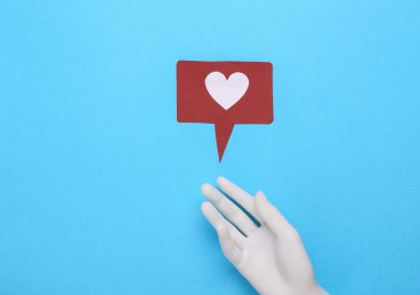 Mavi arka planda bildirim simgesi olan plastik el. Sosyal medya. Beğeni, takipçiler geri bildirim