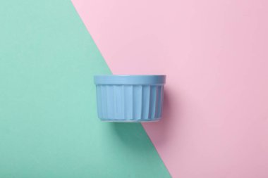 Jülyen için mavi-pembe pastel arka planda seramik kase. Üst görünüm