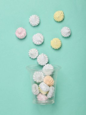 Mavi arka planda tatlı renkli kremalı plastik bardak. Üst Manzara. Düz yatıyordu