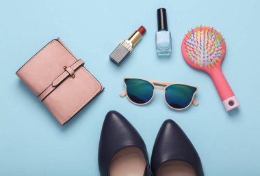 Mavi-pembe arka planda kadın topuklu ayakkabılar ve aksesuarlar. Üst Manzara. Düz yatıyordu