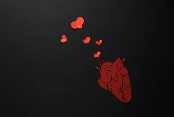 Love concept. Anatomical heart and love hearts on black background. Valentine\'s Day. 14th February