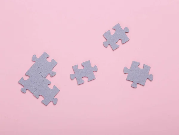 Puzzle pieces on a pink background. Top view. Mental health, business, concept