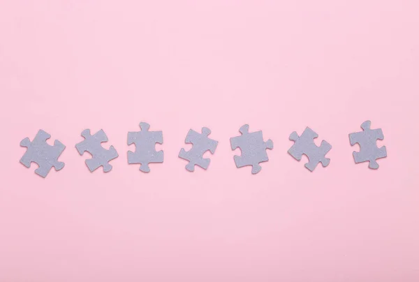 Puzzle pieces on a pink background. Top view. Mental health, business, concept