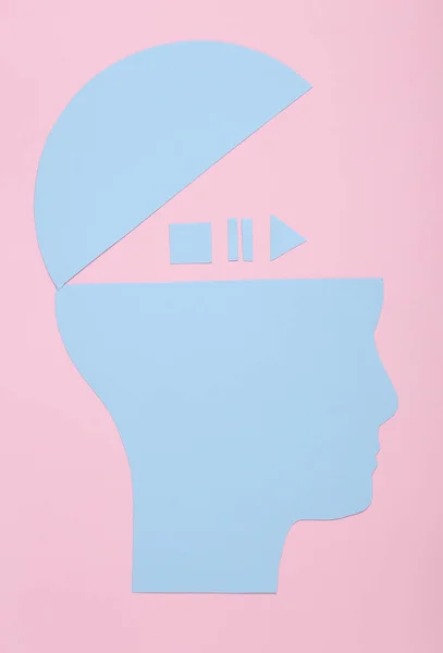 Paper head silhouette with icons start, stop, pause of media player on pink background. Top view