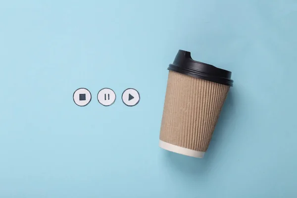 Coffee cup with icons start, stop, pause of media player on blue background. Top view