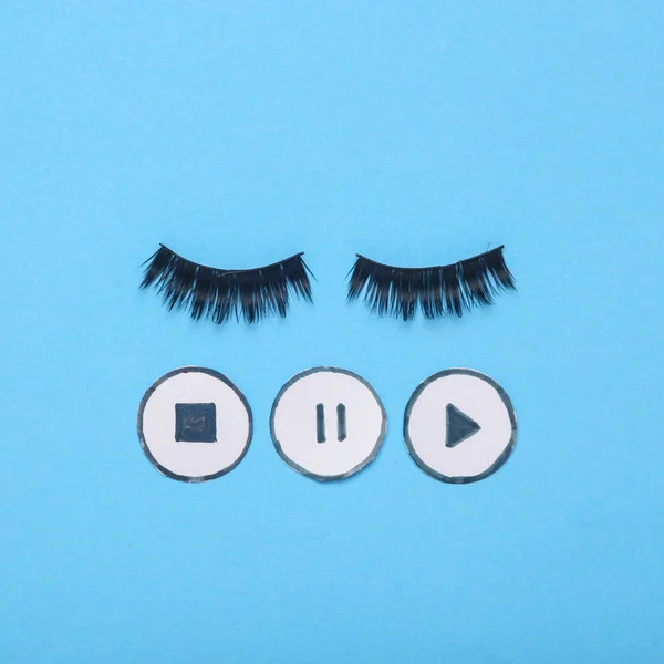 Concept pop minimal still life false eyelashes with start, pause, stop media player icons on blue background