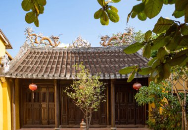 Hoi An, Vietnam - November 21, 2019: The entrance with wooden decorations of an ancient temple