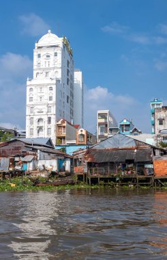 Cai Rang, Vietnam - November 25, 2019: The typical narrow vertical condominiums and the shacks on stilts seen from the Mecong river