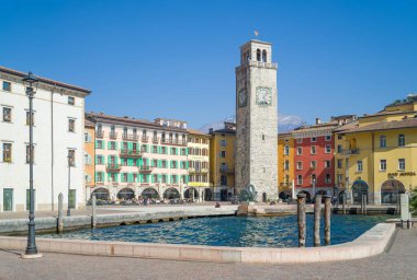 Riva del Garda, İtalya - 22 Mart 2022: Ön planda göl limanı olan antik Apponale kulesiyle Catena Meydanı