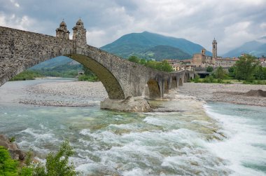 Bobbio, İtalya, Trebbia Nehri üzerindeki Eski Köprü (Şeytan Köprüsü olarak da bilinir), arka planda kalan ülke