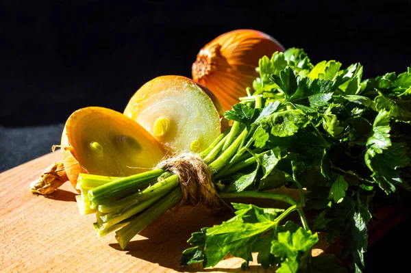 sebzeler, yeşil maydanoz, soğan, ahşap bir kesme tahtasında.