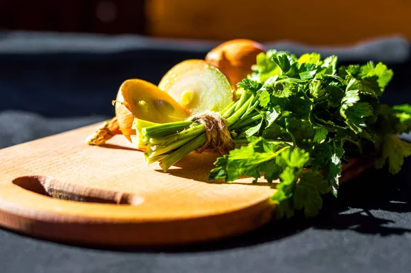 sebzeler, yeşil maydanoz, soğan, ahşap bir kesme tahtasında.