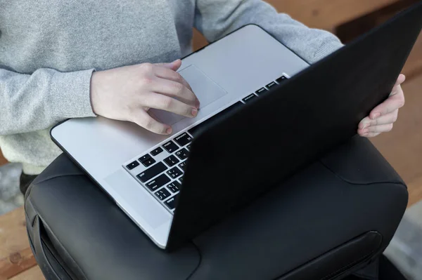 Dizüstü bilgisayarda çalışan bir adam sırt çantasıyla oturur. Laptop kucağımda, rbkzak kucağımda.